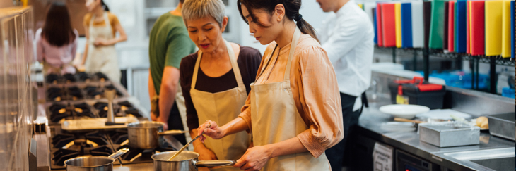 an apprentice chef being taught in a kitchen